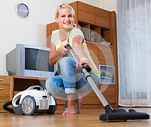 Blonde girl hoovering in living room