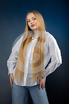 Blonde girl in jeans and white shirt over blue background