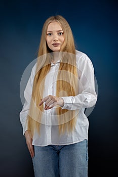 Blonde girl in jeans and white shirt over blue background