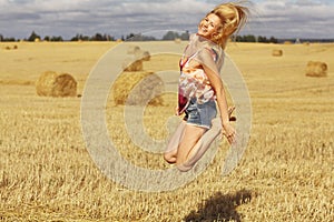 Blonde girl jumps in sloping field