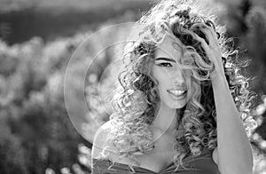 Blonde girl with long and curly wavy hair. Beautiful model with curly hairstyle. Fashion haircut. Beautiful attractive