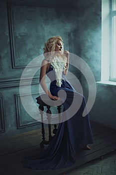 A blonde girl in a luxurious blue dress