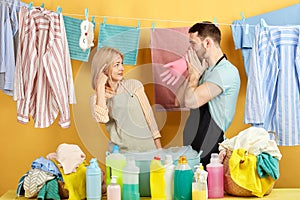 Blonde girl making a screw loose sign as her husband inflating protective latex gloves