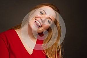 A blonde girl with an overweight plus size, in a red overallposing on a dark Studio background