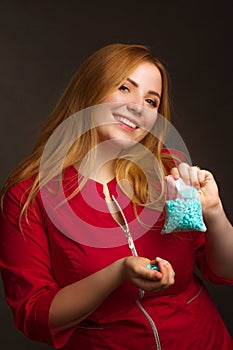 A blonde girl with an overweight plus size, in a red overallposing on a dark Studio background