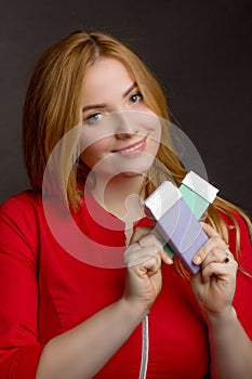 A blonde girl with an overweight plus size, in a red overallposing on a dark Studio background