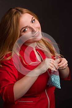 A blonde girl with an overweight plus size, in a red overallposing on a dark Studio background