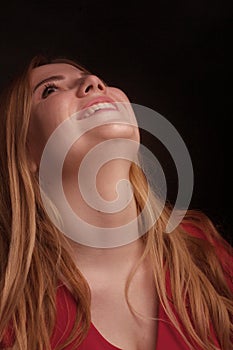 A blonde girl with an overweight plus size, a red overallposing on a dark Studio background