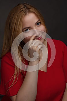 A blonde girl with an overweight plus size, a red overallposing on a dark Studio background