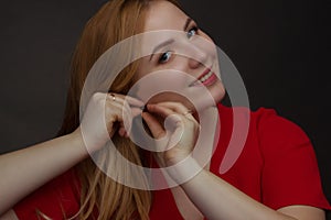 A blonde girl with an overweight plus size, a red overallposing on a dark Studio background