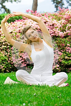 Blonde girl in park doing yoga