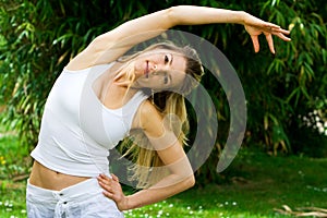 Blonde girl in park doing yoga