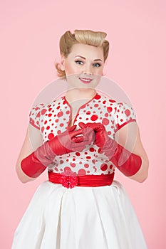 Blonde girl in pinup style on rose background. Happy smiled blonde girl