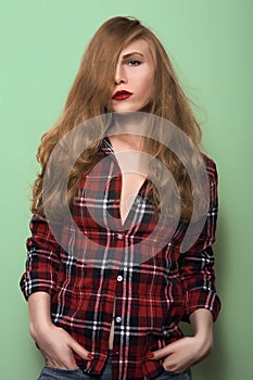 Blonde girl in a plaid shirt and jeans.