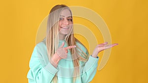 Blonde girl pointing at advertising area on her palm