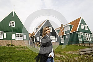 Blonde girl posing in front of traditional houses