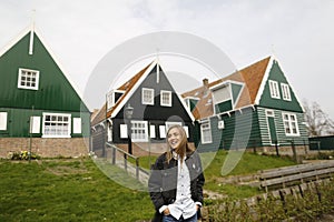 Blonde girl posing in front of traditional houses