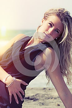 Blonde girl posing at sea. Black dress.