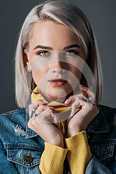 blonde girl posing in yellow turtleneck and jeans jacket