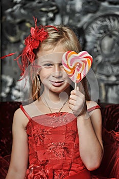 Girl in a red dress with candy in her hands