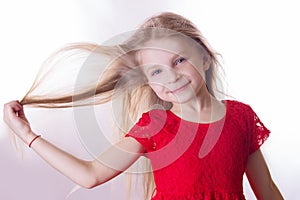 Blonde girl in red dress with waving by wind hair