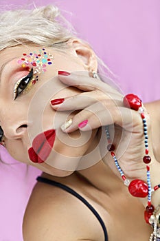 Blonde girl with red manicure and makeup.