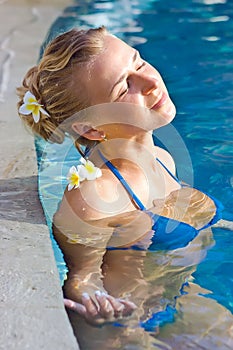 Blonde girl relaxing in hotel pool