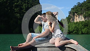 Blonde Girl Speaks with Handsome Guy Sitting on Longtail Boat