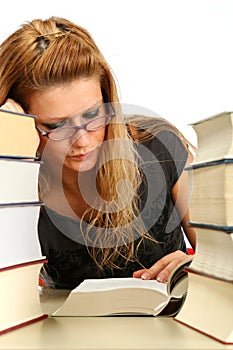 Blonde girl studying between big books