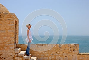 Blonde girl on wall of old castl 1