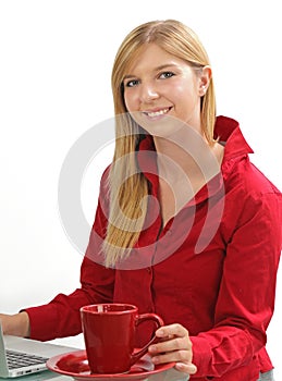 Blonde girl working on a computer with coffee