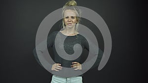 Blonde in grey pullover pulls faces standing on stage