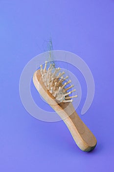 Blonde hair loss problem with hairbrush on blue background. Flying concept.