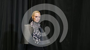 Blonde hair model girl moving on catwalk podium. Female fashion runway defile. photo