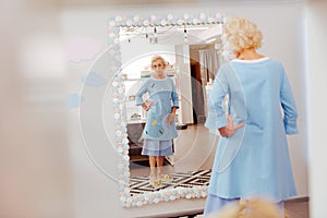 Blonde-haired retired woman trying blue costume on