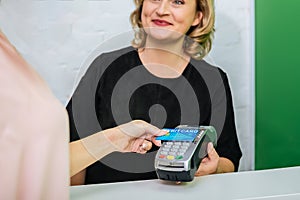 Blonde-haired worker of beauty salon smiling while contacting with client