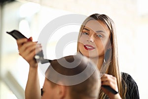 Blonde Hairstylist Cutting Man by Electric Shaver