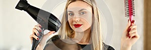 Blonde Hairstylist Showing Blow Dryer and Comb