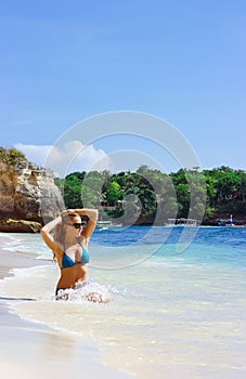 Blonde lady sitting in water on the beach