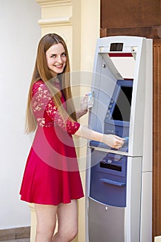 Blonde lady using an automated teller machine