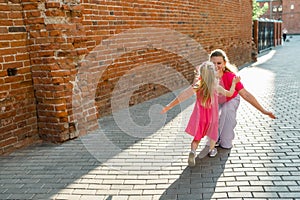 Blonde little girl with cochlear implant playing with her mother outdoor. Hear impairment deaf and health concept