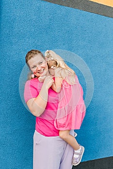 Blonde little girl with cochlear implant playing with her mother outdoor. Hear impairment deaf and health concept