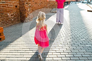 Blonde little girl with cochlear implant playing with her mother outdoor. Hear impairment deaf and health concept