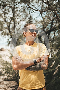 Blonde man with pony tail standing on the beach