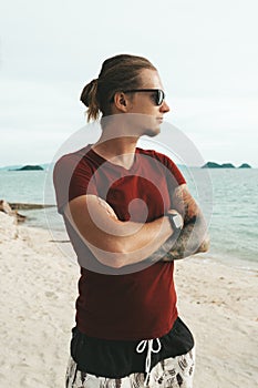 Blonde man with pony tail standing on the beach