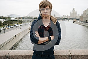 Blonde man is standing on the bridge in Moscow