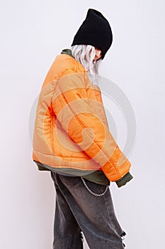 Blonde Model in fashion urban street outfit. Trendy orange bomber jacket and stylish black denim. Fall winter seasons lookbook