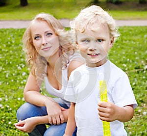 Blonde mother and son playing in the park