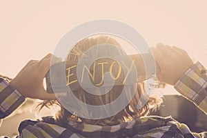 Blonde people young teenager with enjoy written on a natural piace of recycled wood. feeling and golden sunset atmosphere image photo