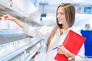 Blonde pharmacist picking medicine and drugs